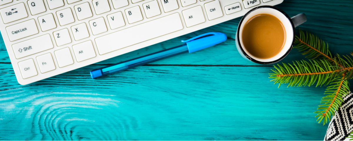 Cup of coffee next to a keyboard.