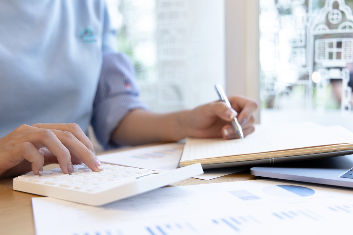 Closeup of individual using calculator to budget expenses. 