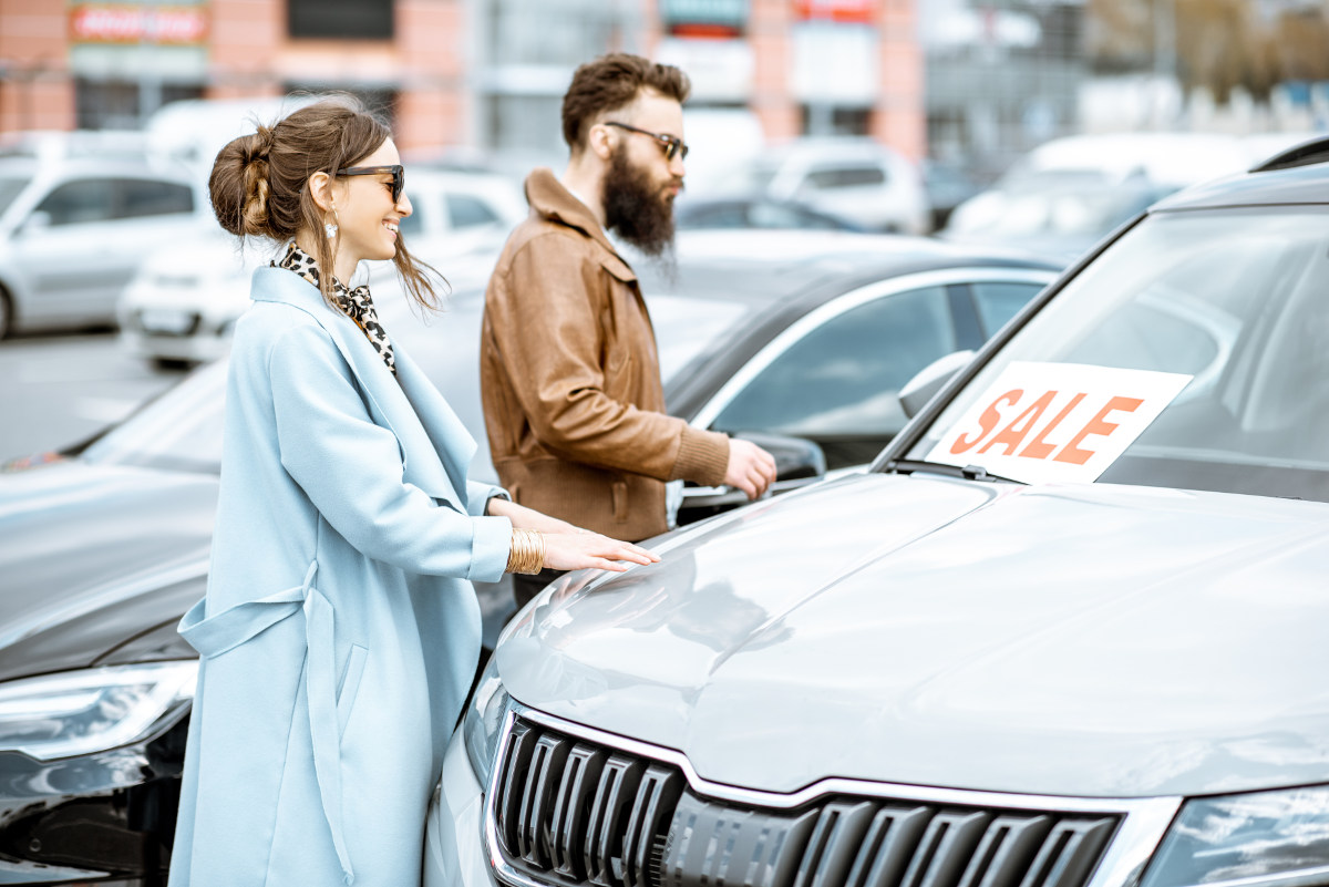 Couple chooses a car in a lot.