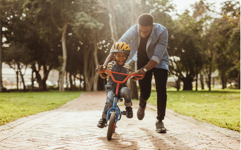 Father teaching his son how to ride a bike.