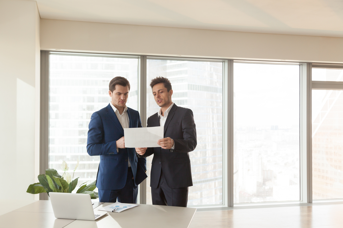 Two business people discussing a document.