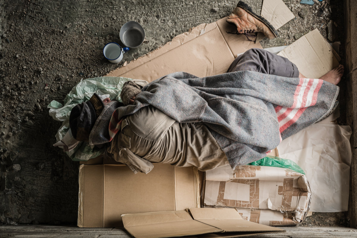 Homeless man on ground.