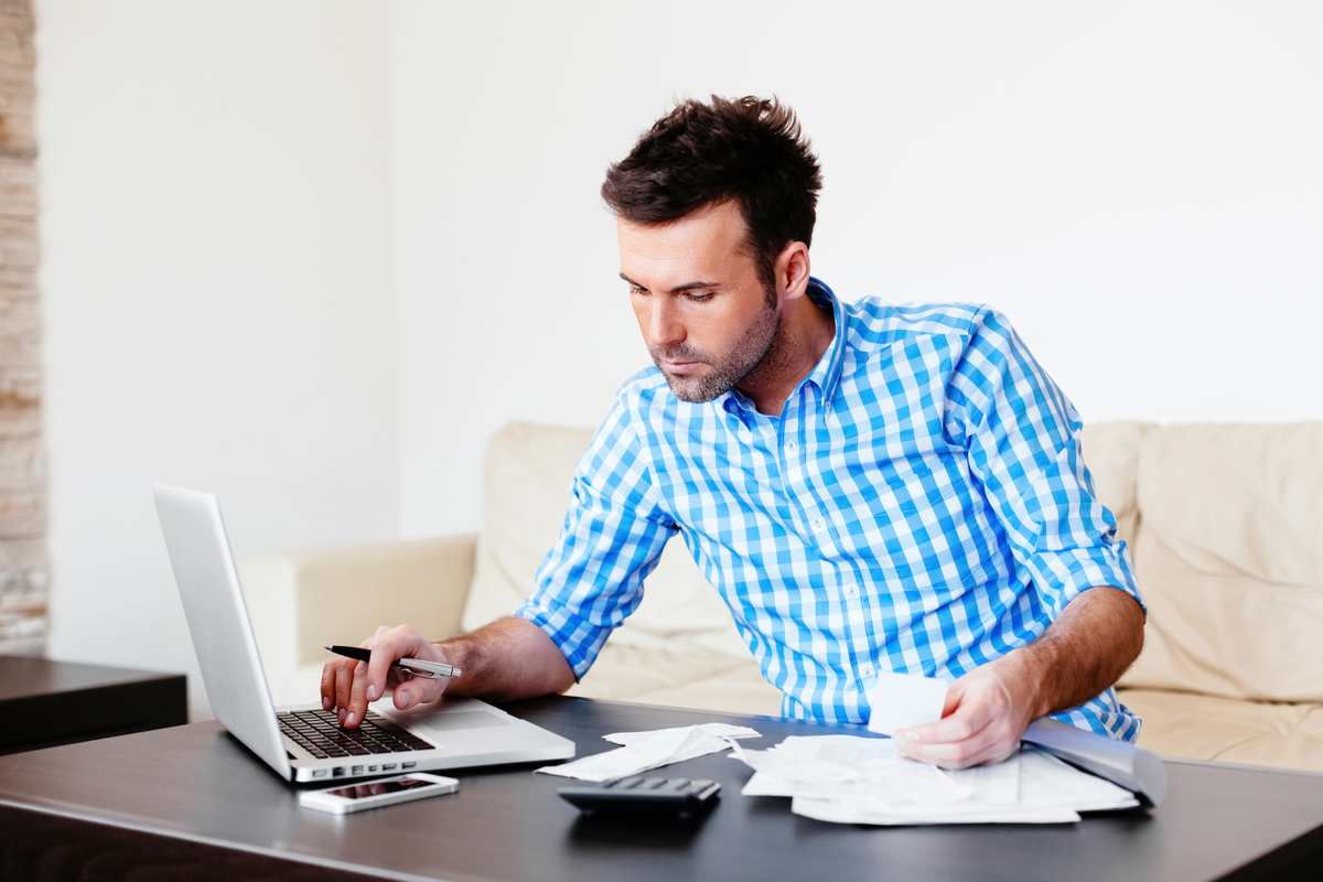 Man using a laptop to make personal loan calculations.
