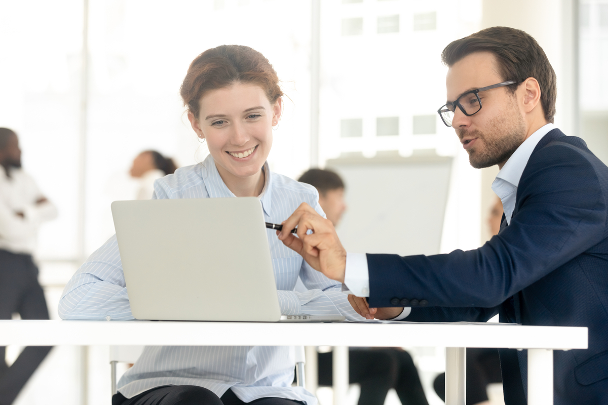 Man showing a woman how to calculate her loan cost.